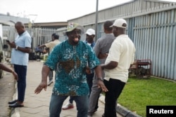 Seorang anggota Kongres Buruh Nigeria (NLC) di depan Terminal Dua Bandara Murtala Muhammed (MMA2) selama pemogokan Kongres Buruh Nigeria di Lagos, Nigeria, 3 Juni 2024. (REUTERS/Marvellous Durowaiye)