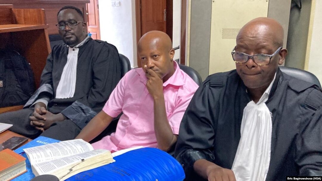 Impirimbanyi y'Uburenganzira bwa muntu Aimable Karasira ari hagati y'abanyamategeko bamwunganira mu rukiko