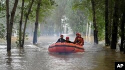 Rescuers ride a rubber boat and head to a village to carry out evacuation operation in the flood-hit Zhuozhou in northern China's Hebei province, Aug. 3, 2023. (Xinhua News Agency via AP)