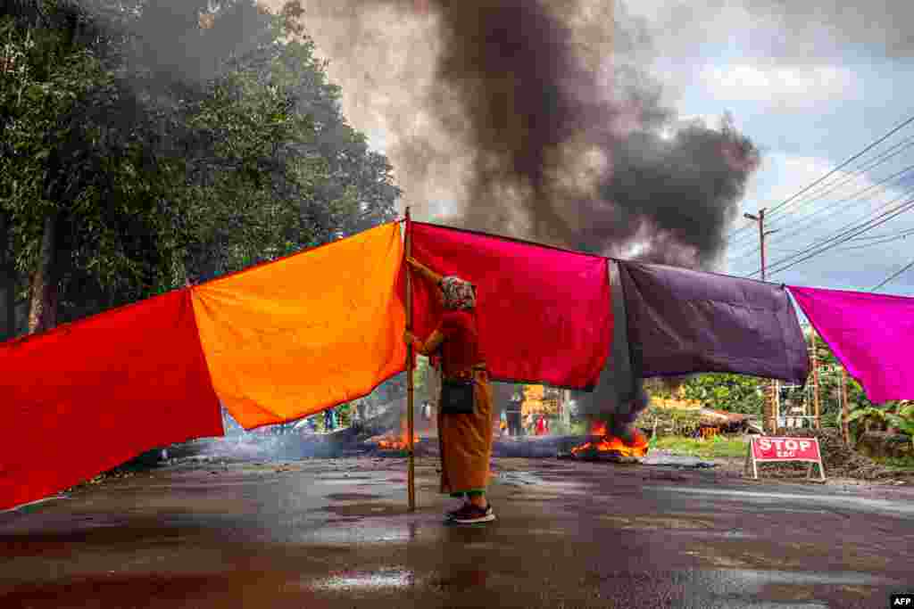 A woman protester blocks a road during 48-hour general strike in Imphal as they demand restoration of peace in India&#39;s northeastern state of Manipur after ethnic violence.