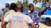 ARCHIVES - Un policier fait signe à un journaliste lors d'un sit-in près de la présidence, pour protester contre une nouvelle loi sur les médias à Lomé, au Togo, le 14 mars 2013.