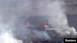 Zapaljene kuće u srpskom selu Svinjare, blizu Mitrovice, 18. mart 2004.