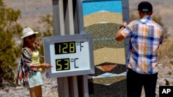 Turis mengambil foto dengan termometer di Pusat Pengunjung Furnace Creek selama cuaca panas ekstrem yang berbahaya di Death Valley, California 9 Juli 2024 lalu (foto: dok). 