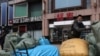 FILE - A man moves bags of goods for export in front of a trading centre that houses shops and offices with Russian goods and services, in Beijing, China April, 1 2022.