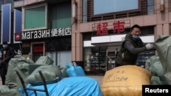 中國北京一名男子在一個出售俄羅斯商品和服務的交易中心前搬運出口貨物。 （2022年4月1日）