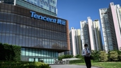 Seorang pria berjalan melewati markas raksasa teknologi asal China, Tencent, di Shenzen, provinsi Guangdong, pada 10 Juli 2022. (Foto: AFP/Jade Gao)