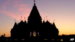 The sun sets at the BAPS Swaminarayan Akshardham, the largest Hindu temple outside India in the modern era, Oct. 4, 2023, in Robbinsville, NJ.