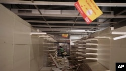 Boys inside a destroyed supermarket in Dakar, Senegal, June 3, 2023. Senegal's government says 15 people have been killed in clashes between police and supporters of Ousmane Sonko.