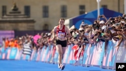 Kinzang Lhamo, of Bhutan, approaches the finish line at the end of the women's marathon competition at the 2024 Summer Olympics, in Paris, France, Aug. 11, 2024. 