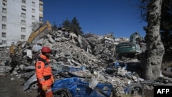 A rescuer stands in front of rubble near the site where Aleyna Olmez, 17, was rescued from a collapsed building, 248 hours after the earthquake which struck parts of Turkey and Syria, in Kahramanmaras, Feb. 16, 2023. 