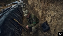 A Ukrainian soldier sits in a trench at the frontline near Bakhmut in the Donetsk region, Ukraine, May 22, 2023. 