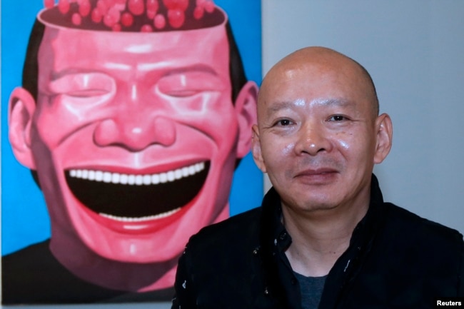 中国艺术家岳敏君与他的绘画（记忆-2，2000）在巴黎展出。（2012年11月13日）