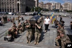 Ukrainian servicemen carry the coffin of British combat medic, volunteer, Peter Fouche, 49, who was killed on June 27, 2024, during his work in East Ukraine, at the funeral ceremony on the city's main square in Kyiv, Ukraine, July 6, 2024.