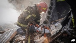 In this photo provided by the Ukrainian Emergency Service, Ukrainian emergency personnel work at the site of Russia's air attack in Khmelnytskyi, Ukraine, March 22, 2024. 