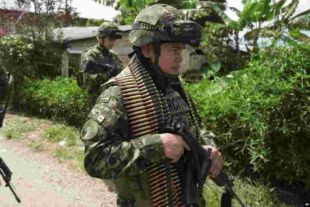 Soldiers patrol on the outskirts of Morales, Colombia, after an attack, May 20, 2024. 