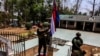 ทหารของกองกำลังปลดปล่อยชาติกะเหรี่ยง ขณะกำลังนำธงกะเหรี่ยงขึ้นสู่ยอดเสาที่หมู่บ้านตีงาหยี่หน่อง Thing Nga Nyi Naung Village เมืองเมียวดี แทนที่ธงเมียนมาที่เพิ่งเผาทำลายไป วันที่ 15 เมษายน 2024 (ที่มา: รอยเตอร์)