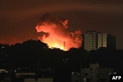 Vatra i dim uzdižu se iznad stambenih zgrada u gradu Gaza, tokom izraelskih vazdušnih udara, 13. oktobra 2023.