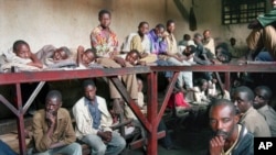 FILE - Some of the 334 inmates in a prison who are accused of committing war crimes and participating in the genocide, sit in the prison in Kibungo, Rwanda, Aug. 17, 1994.