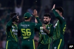 Pakistan's Shadab Khan, second right, celebrates with teammates after taking the wicket of New Zealand's Michael Bracewell during the fifth T20 international cricket match between Pakistan and New Zealand, in Lahore, Pakistan, April 27, 2024.