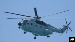 菲律宾海岸警卫队发布照片显示，一架中国军用直升机在有争议的南中国海飞近一艘正驶近铁线礁（Sandy Cay ）的菲律宾政府船只。（2024年3月21日）