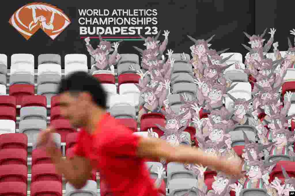 An athlete runs past cutouts of the World Athletics Championships' mascot, Youhuu, a native Hungarian sheep, at the National Athletics Centre, one day ahead of the start of the championships in Budapest, Hungary.