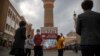 FILE - Tourists take photos near a tower at the International Grand Bazaar in Urumqi in western China's Xinjiang Uyghur Autonomous Region, as seen during a government-organized trip for foreign journalists on April 21, 2021.