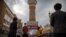 FILE - Tourists take photos near a tower at the International Grand Bazaar in Urumqi in western China's Xinjiang Uyghur Autonomous Region, as seen during a government-organized trip for foreign journalists on April 21, 2021.