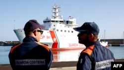 FILE - Italian coast guard officers wait for migrants to disembark from the Italian Coast Guard's patrol vessel Diciotti at the port of Crotone, in the southern Calabria region, Oct. 27, 2022.