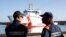 FILE - Italian coast guard officers wait for migrants to disembark from the Italian Coast Guard's patrol vessel Diciotti at the port of Crotone, in the southern Calabria region, Oct. 27, 2022.