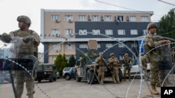 FILE - U.S. soldiers, part of the peacekeeping mission in Kosovo KFOR guard a municipal building in the town of Leposavic, northern Kosovo, May 29, 2023.