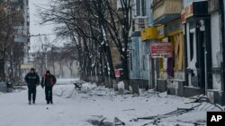 FILE: Local residents walk along a street in Bakhmut, Donetsk region, Ukraine, Feb. 12, 2023. 