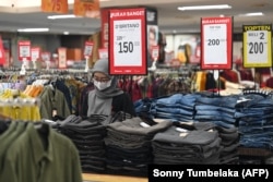 Seorang karyawan sedang menunggu pelanggan di sebuah toko baju di mall di Denpasar, Bali, Jumat, 5 Mei 2023. (Foto: Sonny Tumbelaka/AFP)