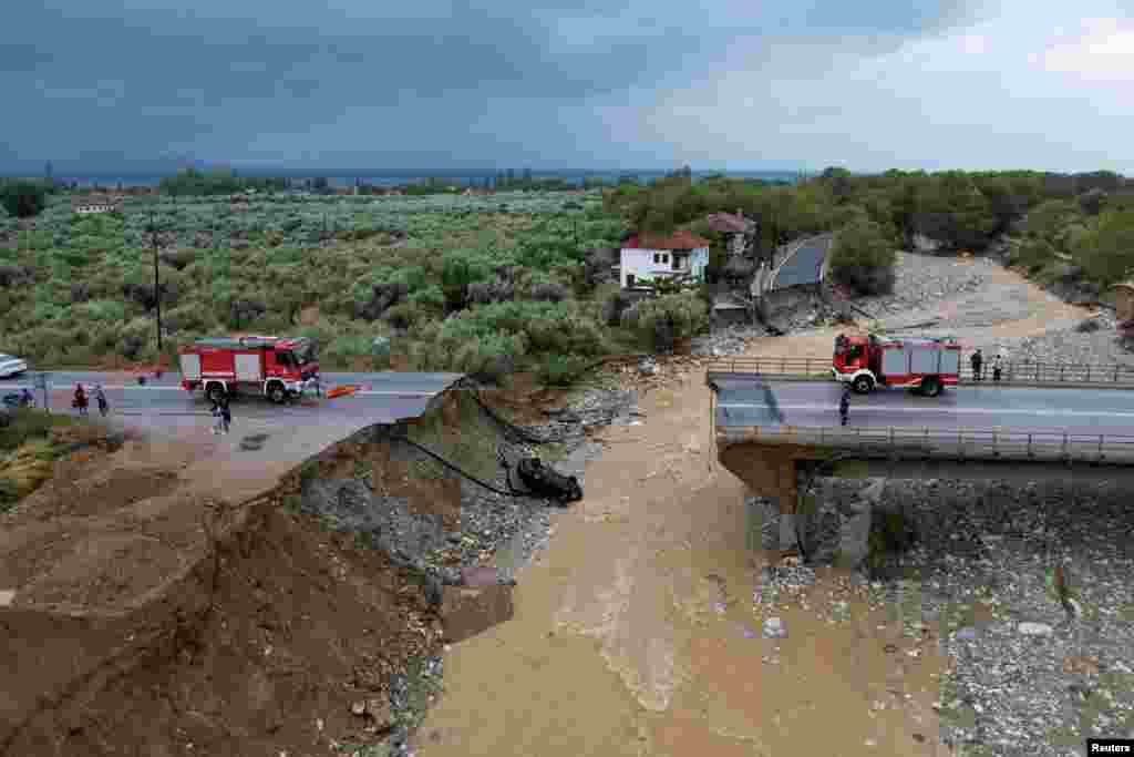 Firefighting crews are seen on a collapsed bridge in the village of Kala Nera as storm Daniel hits central Greece.