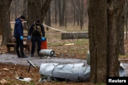 Police officers inspect a part of a Russian Kh-55 cruise missile, intercepted during a missile strike, amid Russia's attack on Ukraine, in a park in Kyiv, March 24, 2024.