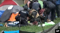Police take down tents and detain protesters from at the University of Virginia on May 4, 2024, in Charlottesville, Va.
