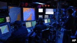 US Navy sailors work in the Combat Information Center of the USS Paul Hamilton in the Strait of Hormuz, May 19, 2023.