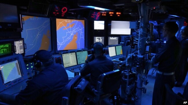 US Navy sailors work in the Combat Information Center of the USS Paul Hamilton in the Strait of Hormuz, May 19, 2023.