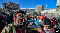 Turkish rescue workers from Kazakhstan and Turkey pull out Hatice Akar from a collapsed building 180 hours after the earthquake in Kahramanmaras, southern Turkey, early Monday, Feb. 13, 2023.