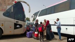 Des passagers fuyant le Soudan déchiré par la guerre débarquent à la gare routière de Wadi Karkar près de la ville égyptienne d'Assouan, le 25 avril 2023.