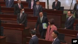 In this image from video taken Oct. 25, 2023, and released by Hong Kong Legislative Council, Hong Kong Chief Executive John Lee enters the Legislative Council meeting room to deliver a policy address. (Hong Kong Legislative Council Pool via AP)