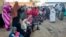 FILE - People from states of Khartoum and al-Jazira, displaced by the ongoing conflict in Sudan between the army and paramilitaries, wait to receive aid from a charity organization in Gedaref on December 30, 2023.