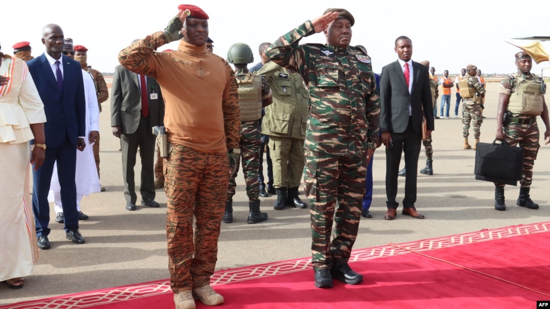 Niger's General Abdourahamane Tiani, right, salutes next to his Burkinabe counterpart Captain Ibrahim Traore left, upon his arrival in Niamey, July 5, 2024.