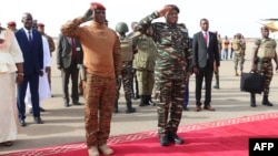 Niger's General Abdourahamane Tiani, right, salutes next to his Burkinabe counterpart Captain Ibrahim Traore left, upon his arrival in Niamey, July 5, 2024.