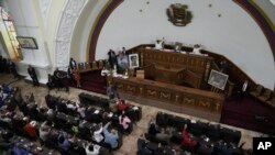 Los miembros de la Asamblea Nacional levantan la mano para iniciar una sesión en Caracas, Venezuela, el jueves 15 de junio de 2023.