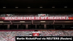 Spanduk dukungan untuk Manchester United terpampang di stadion Old Trafford, Manchester, Inggris, saat laga antara Manchester United dan West Ham United, 22 Juli 2020. (Foto: Martin Rickett/Pool via Reuters)