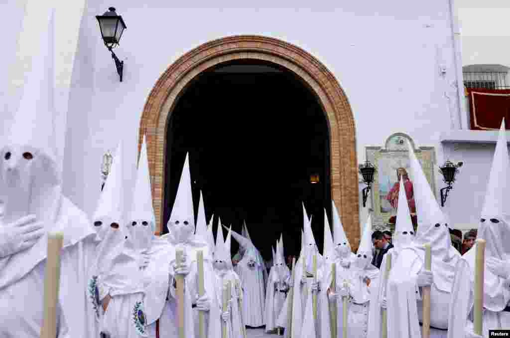 Para peniten yang tergabung dalam persaudaraan La Paz (The Peace) mengambil bagian dalam prosesi Minggu Palma di kota Sevilla, Spanyol. (Reuters)&nbsp;