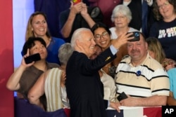 President Joe Biden takes a photo with supporters after speaking at a campaign rally at Sherman Middle School in Madison, Wis., July 5, 2024.