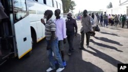 FILE - Freed prisoners join a queue to board a bus after being released from Harare Central Prison in Harare, Zimbabwe, May, 19, 2023. Zimbabwe released more than 4,000 prisoners under a presidential amnesty aimed at easing overcrowding in jails.