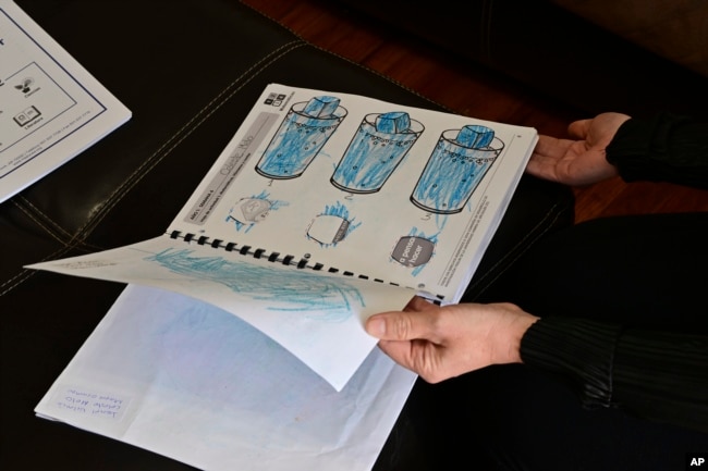 Parent Isabel Valencia holds the first-year program portfolio of her daughter, Celeste on Wednesday, Feb. 28, 2024. (AP Photo/Eric Lars Bakke)