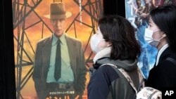 Orang-orang berjalan melewati poster promosi film "Oppenheimer" di Tokyo, Jumat, 29 Maret 2024. “Oppenheimer” akhirnya ditayangkan di negara yang dua kotanya hancurk akibat senjata nuklir, 79 tahun yang lalu. (AP/Eugene Hoshiko)